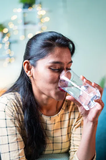 young woman drinking a glass of water