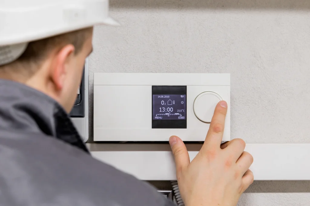 HVAC professional adjusts thermostat