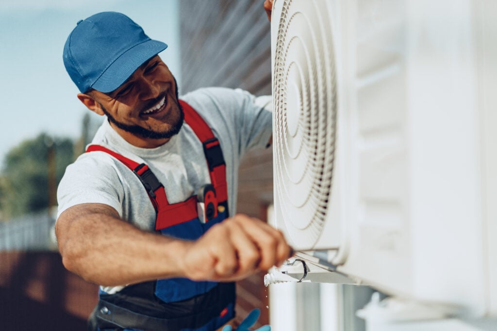 a technician is working on a HVAC system with a smiling face