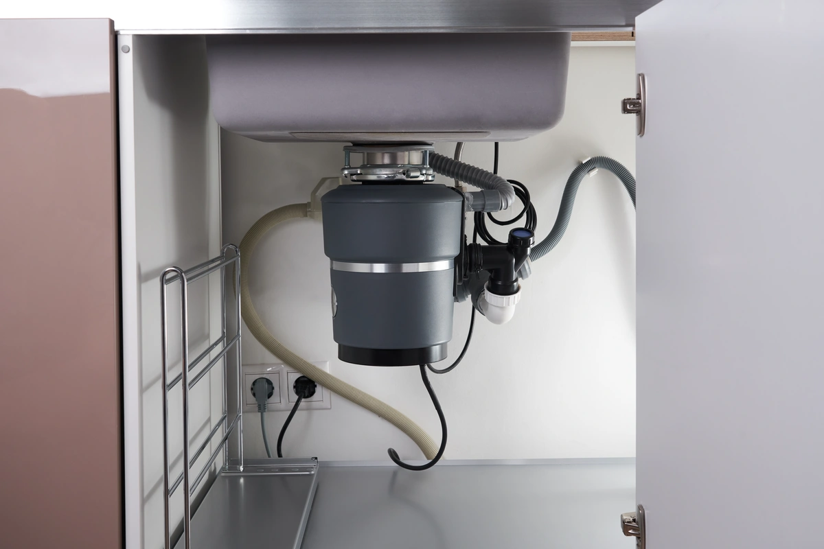 garbage disposal unit under a kitchen sink