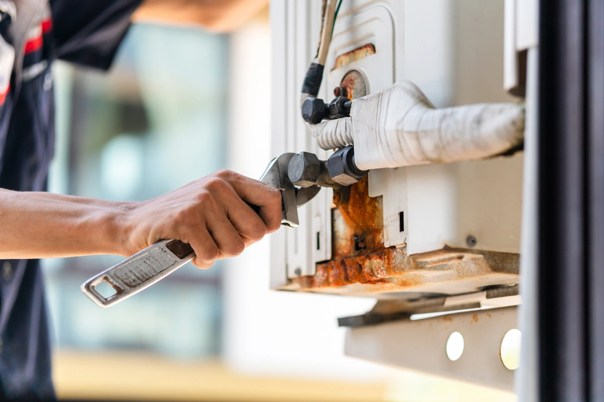 heat not working in house-technician using hand tools on furnace system