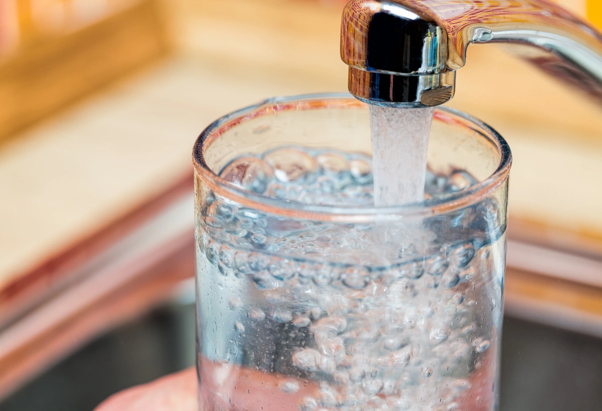water tastes weird-close up of a glass being filled with water from the tap faucet