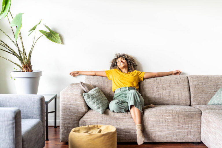 how does ac work-woman sitting on her couch enjoying the ac