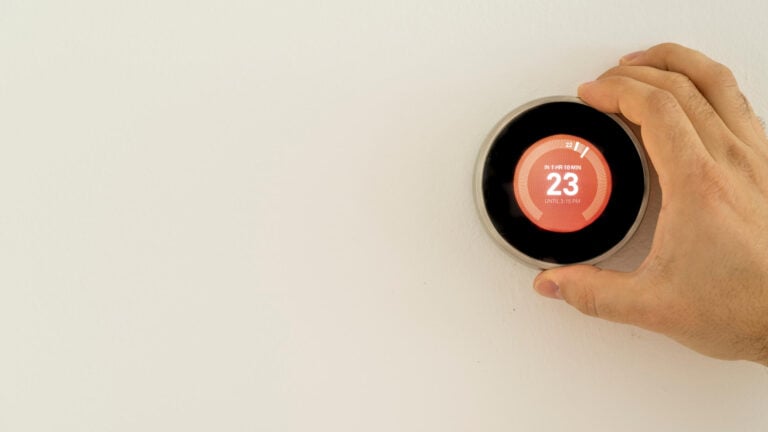 how to calibrate a thermostat-hand adjusting a dial thermostat