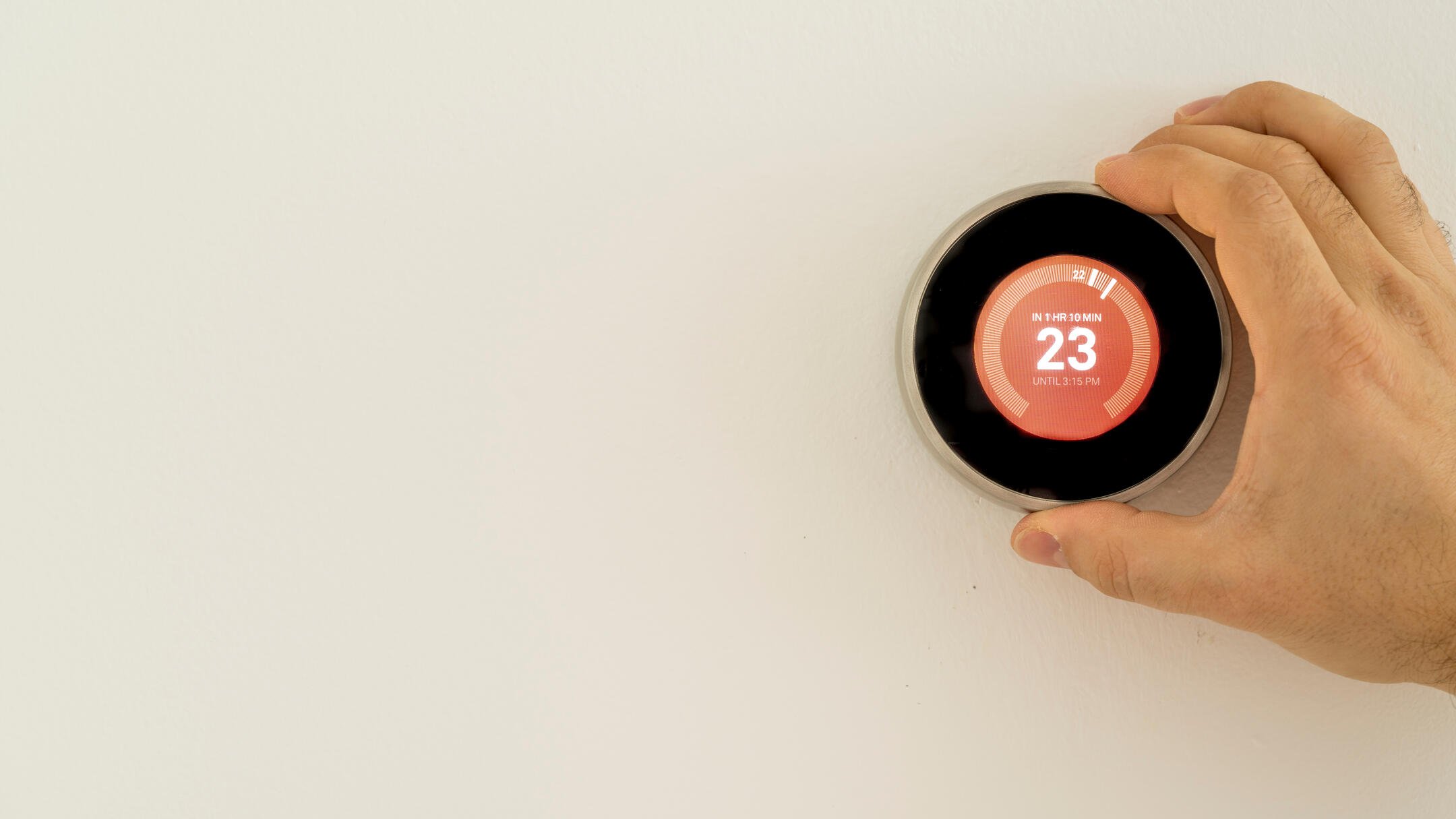 how to calibrate a thermostat-hand adjusting a dial thermostat