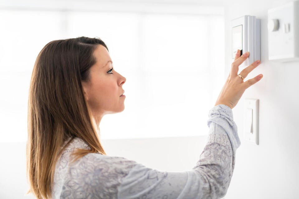how to calibrate a thermostat-woman trying to adjust her thermostat