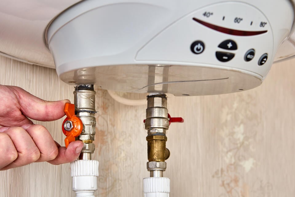 tankless water heater installation-hand adjusting knobs on water heater