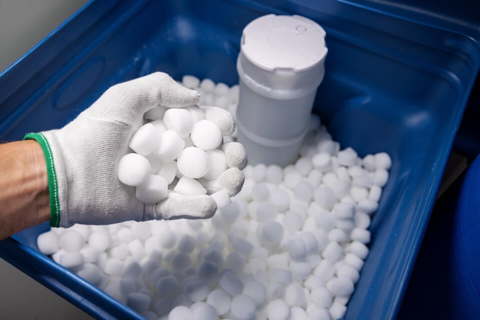 best water softener salt-gloved hand holding water softener tablets