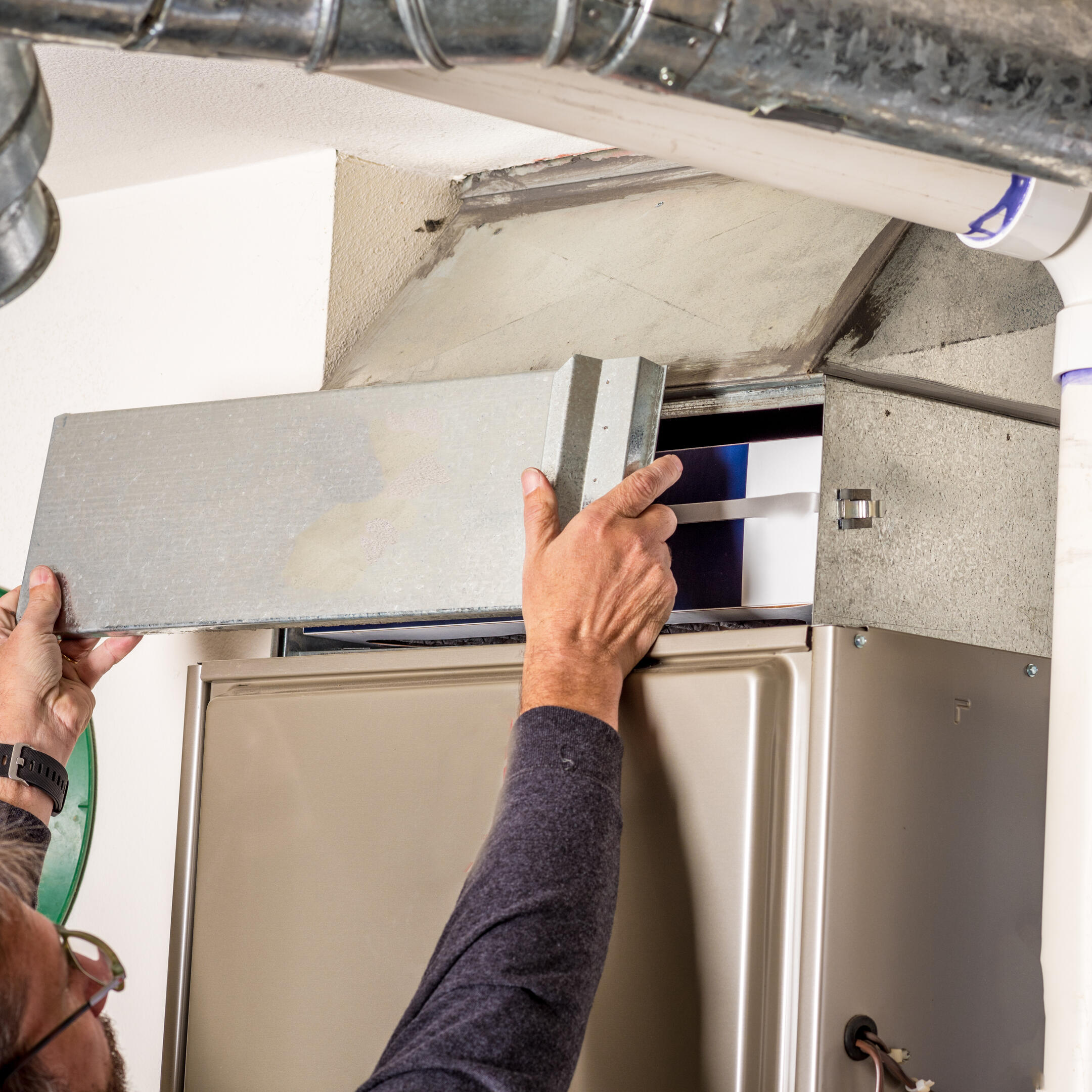 furnace replacement-person removing a door on a furnace
