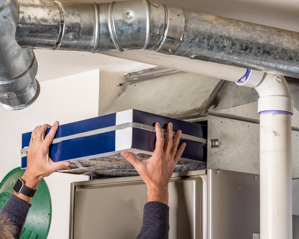 furnace replacement-person replacing furnace filter