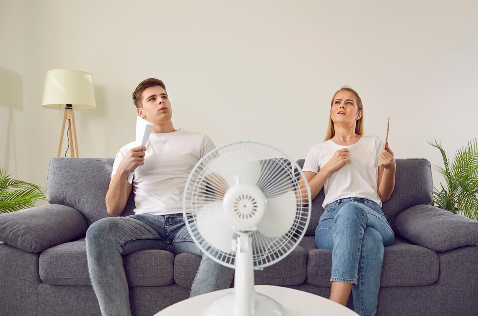 low refrigerant-man and woman sitting on couch overheating because ac is not working properly