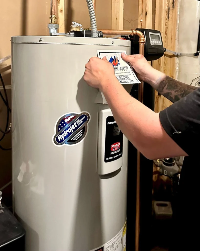 thelen technician placing a branded sticker on a newly installed water heater in Minneapolis, MN