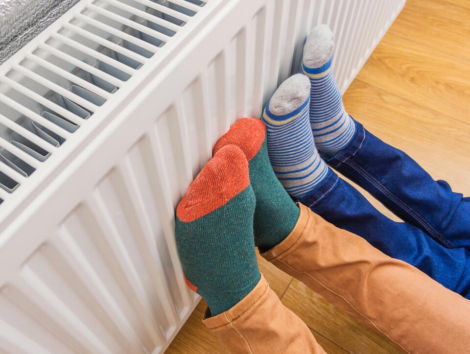 radiator heater-kids feet resting on warm radiator in a home