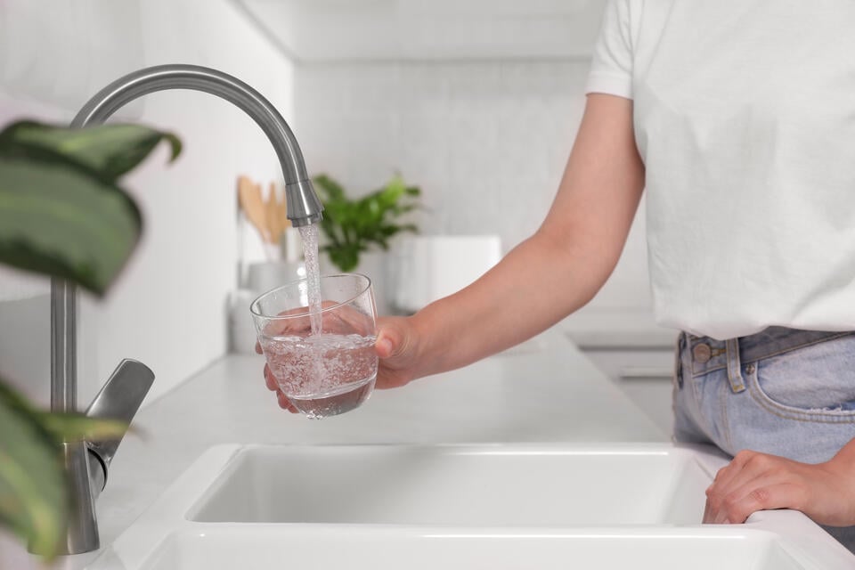 whole house water filter-woman filling a glass of water from tap