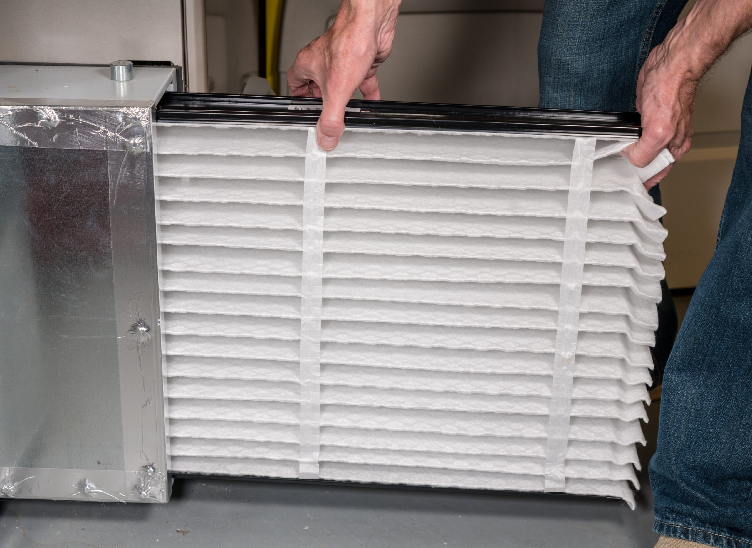 man inserting new filter to furnace