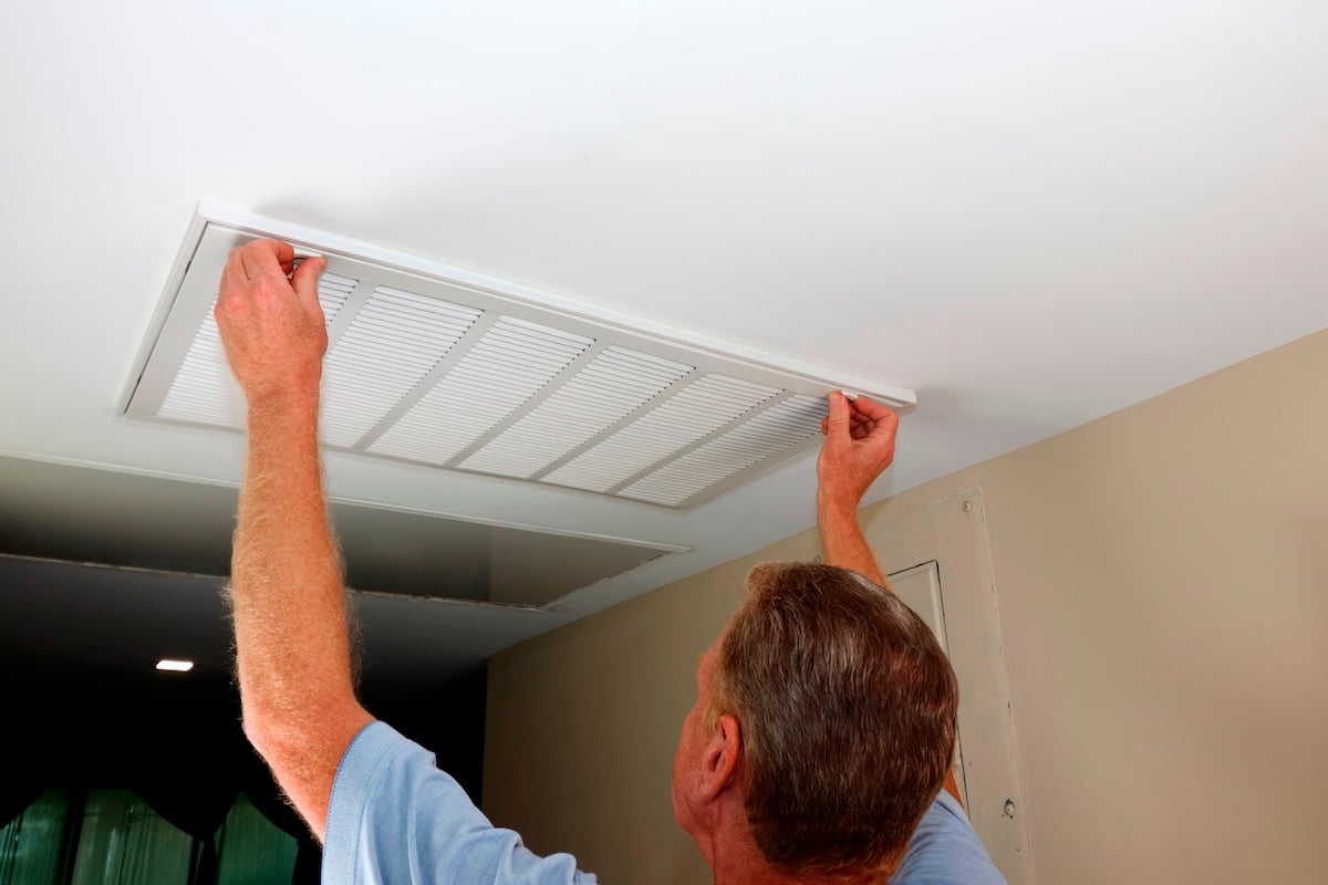 man replacing hvac air purifier filter