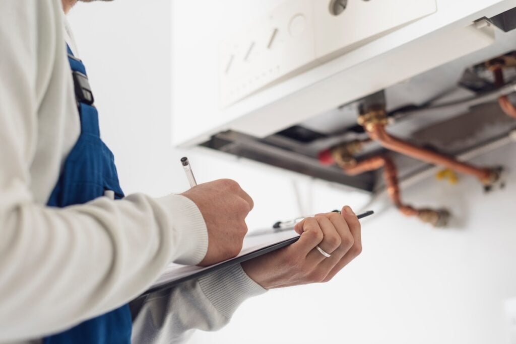 thelen plumber taking notes on boiler installation