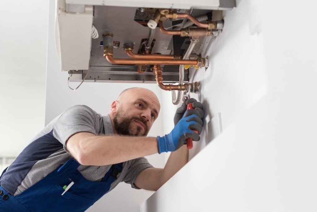 worker screwing in new boiler