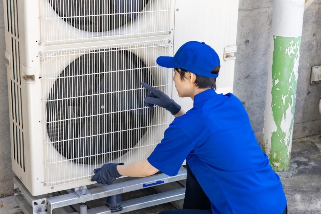 Worker inspecting the outdoor unit