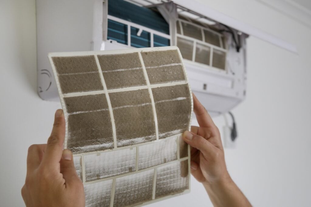 Man holding very dirty air conditioner filter how to find ac filter