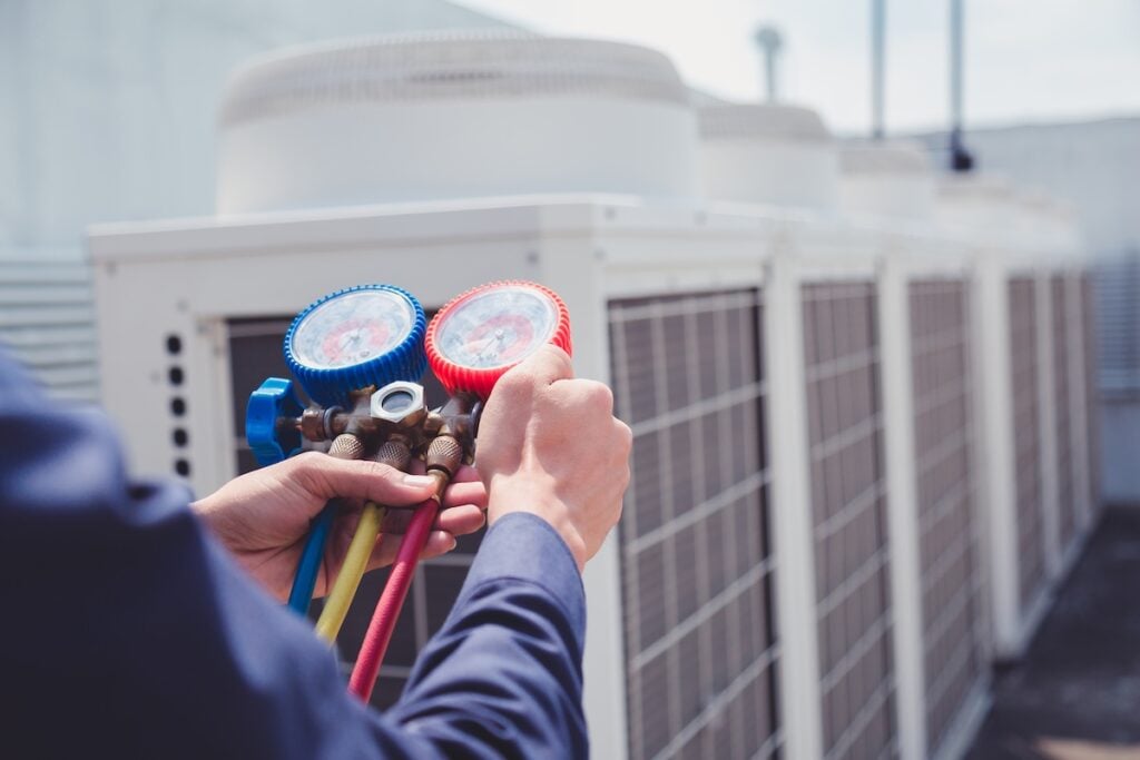 Technician is checking air conditioner ,measuring equipment for filling air conditioners.