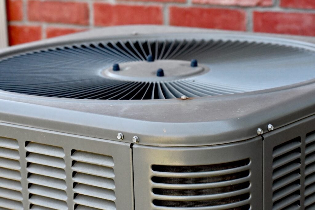 Outdoor air conditioning unit with brick wall background