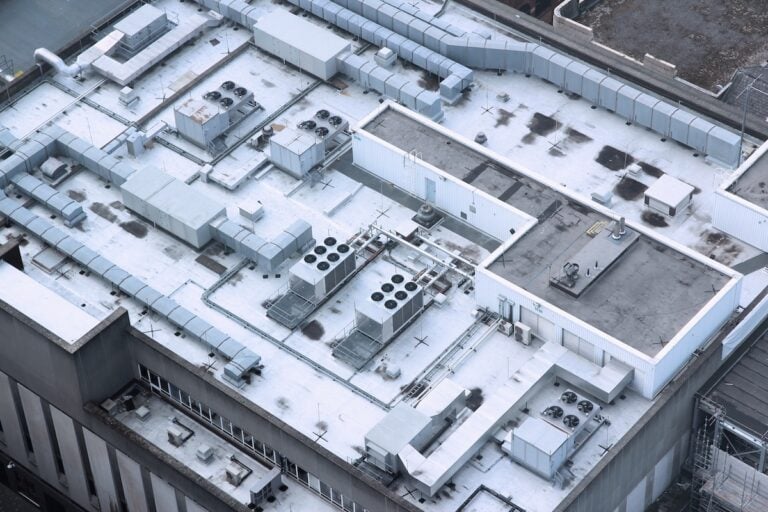 Exhaust vents of industrial air conditioning and ventilation units. Building roof top in Liverpool, UK.