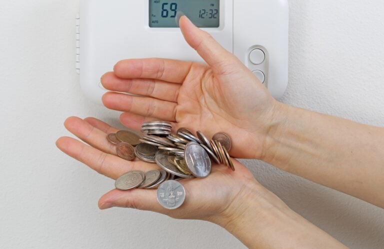 Close up of female hands spilling money due to heating costs. Financial loss of money concept.