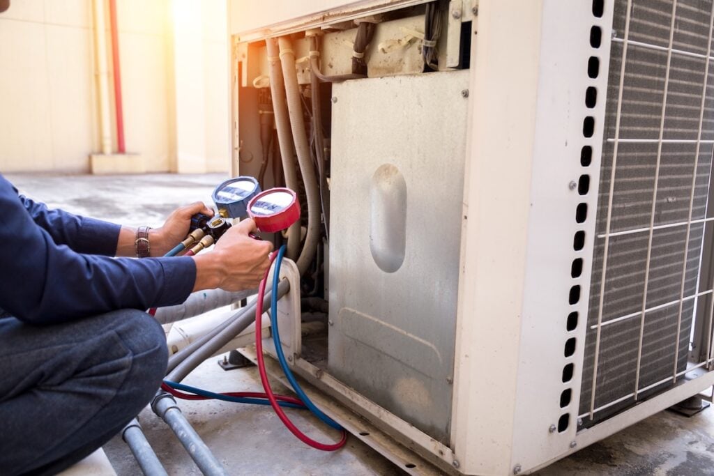 Technician is checking air conditioner ,measuring equipment for filling air conditioners.