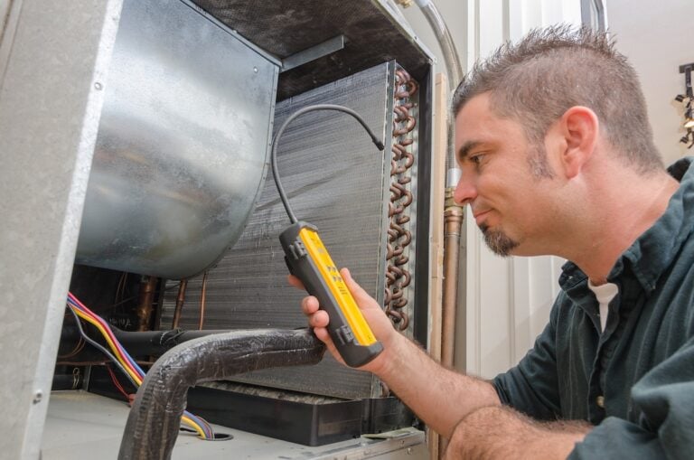 An Hvac technician searching for a refrigerant leak on an evaporator coil.